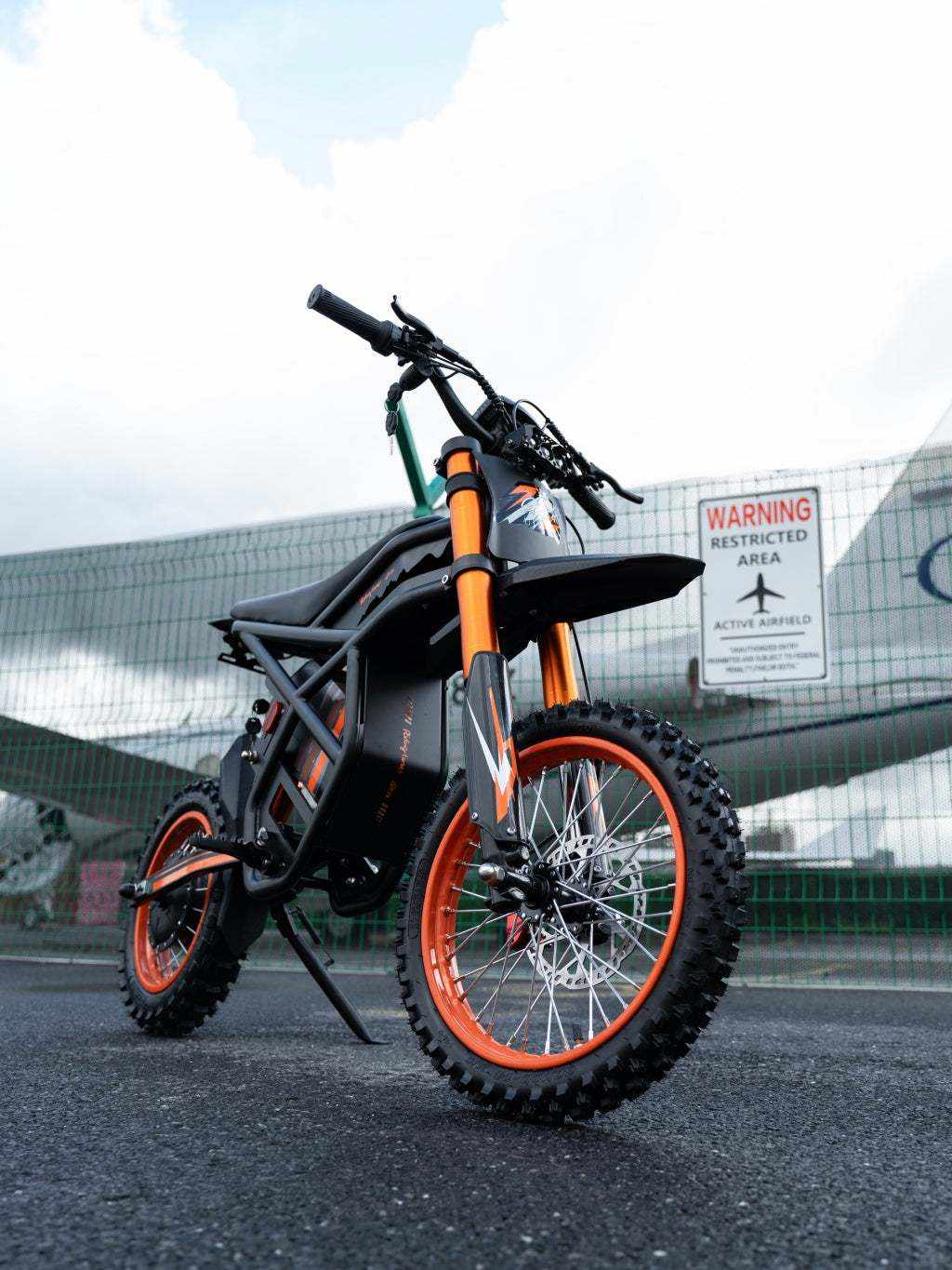 GT54 Electric Mini Motorbike with black frame and orange accents featuring knobby tires and a rugged off-road design