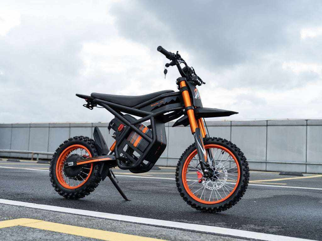 GT54 Electric Mini Motorbike in black and orange with rugged knobby tires, tubular frame, and front suspension fork