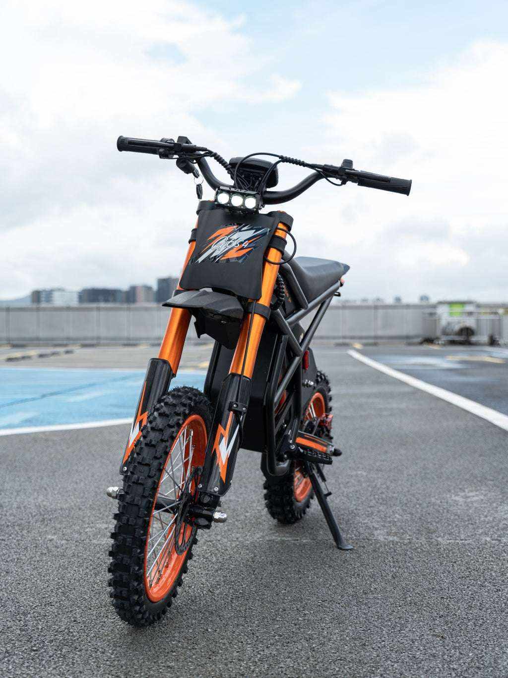 GT54 Electric Mini Motorbike with black and orange frame, knobby tires, and front LED lights for off-road performance