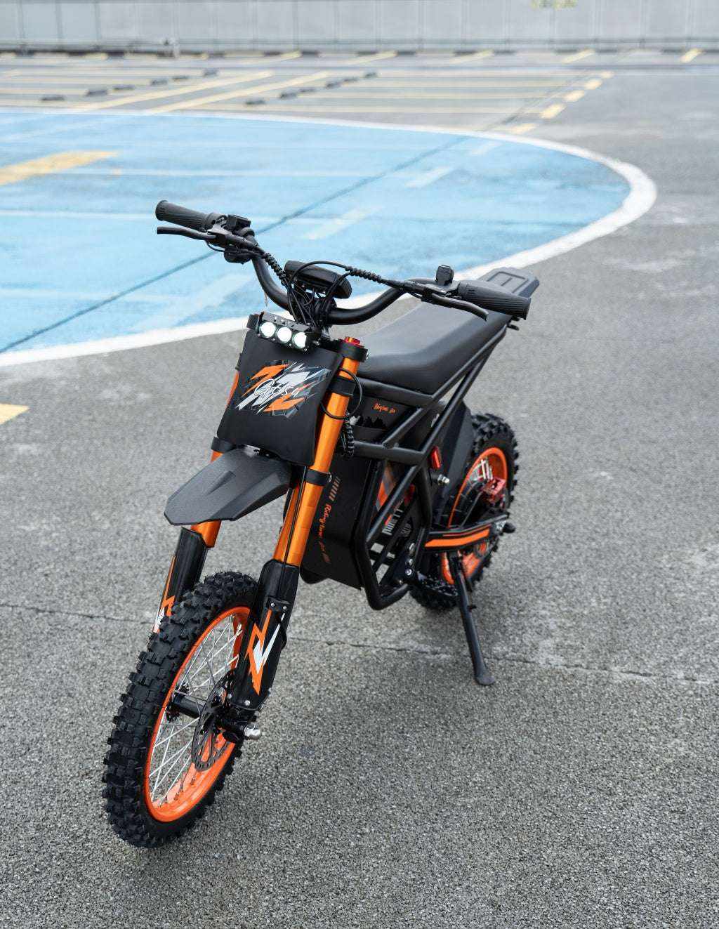 GT54 Electric Mini Motorbike with black and orange frame, knobby tires, and compact electric motor for off-road use