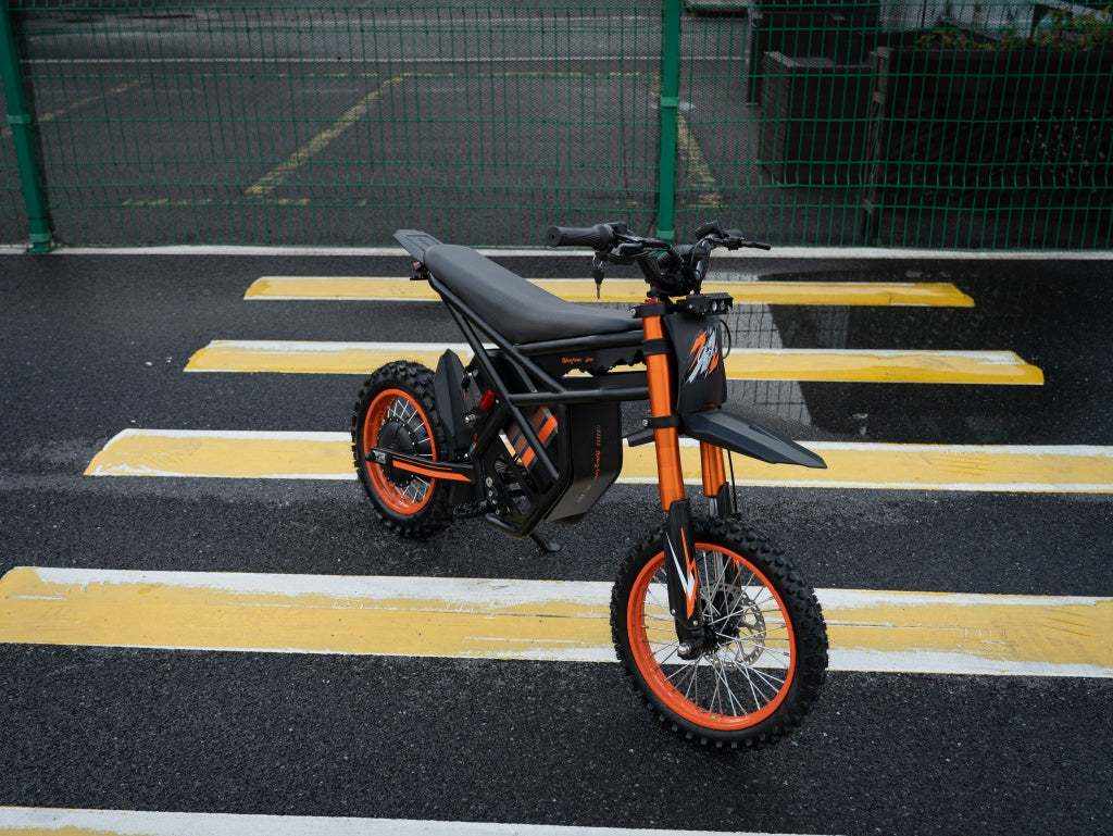 GT54 Electric Mini Motorbike in black and orange with knobby tires, metal frame, and off-road style design for teenagers and adults