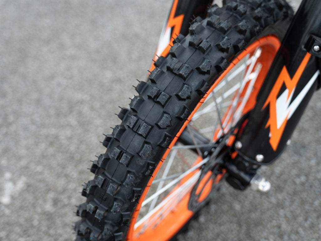 GT54 Electric Mini Motorbike close-up of front wheel with black knobby tire and orange rim featuring black fork with orange and white graphics