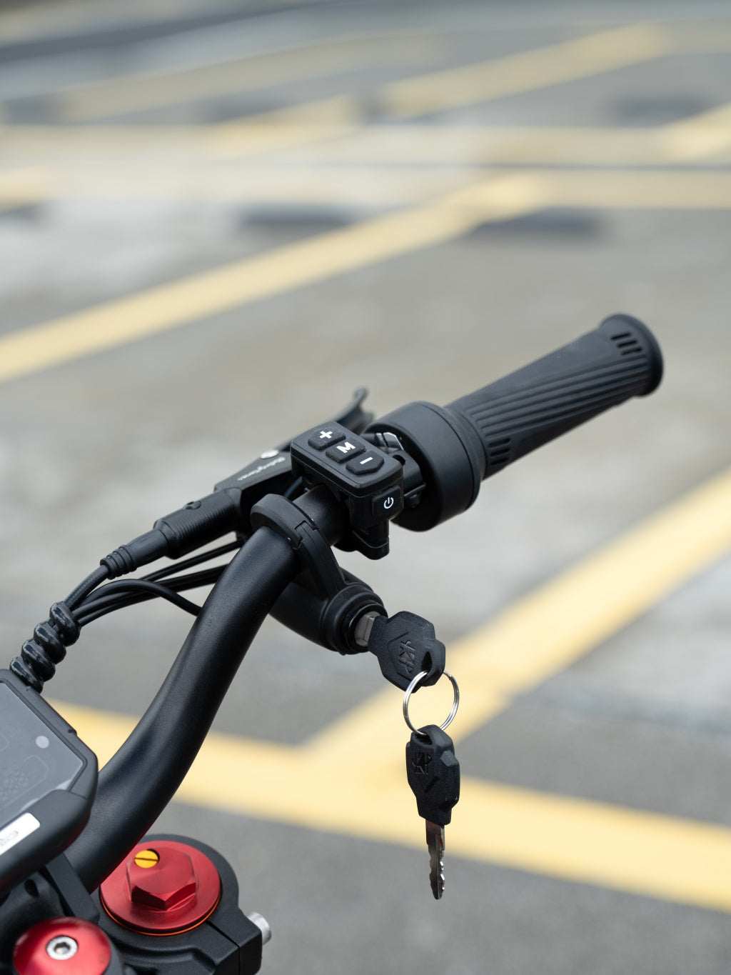 Handlebar grip of GT54 Electric Mini Motorbike with integrated control buttons and a key ignition switch attached