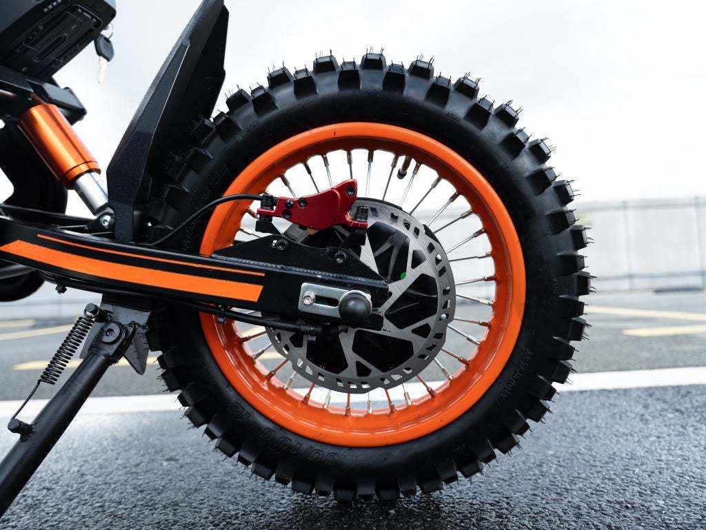 GT54 Electric Mini Motorbike rear wheel with bright orange rim and knobby black off-road tire for enhanced traction