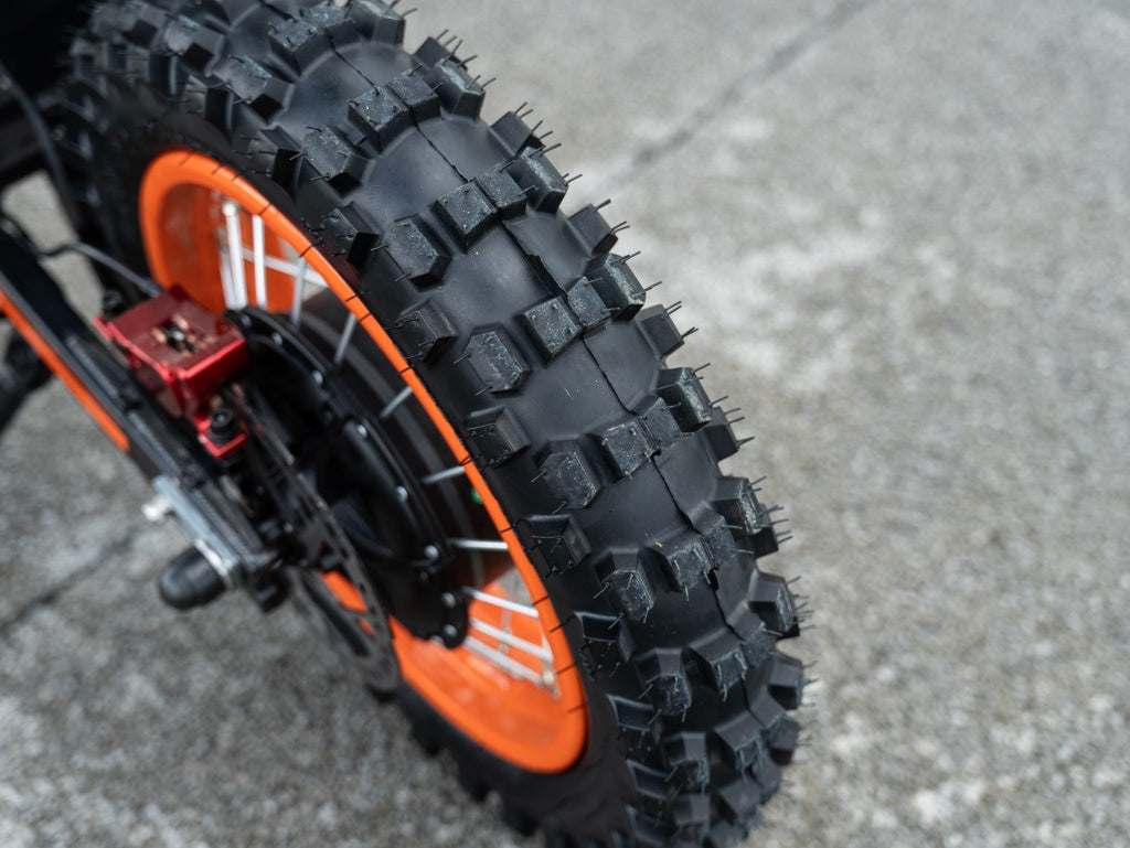GT54 Electric Mini Motorbike rugged black knobby tire with bright orange rim and metal spokes for off-road traction