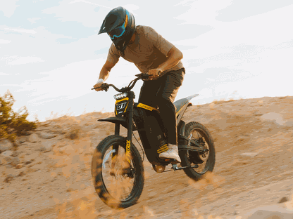 Jasion Patrol 52 black electric dirt bike with yellow accents ridden on rocky dirt terrain by a rider in protective gear