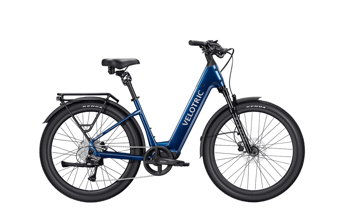 Velotric Discover 3 electric bike in metallic blue with step-through frame, rear rack, hydraulic disc brakes, and fat tires