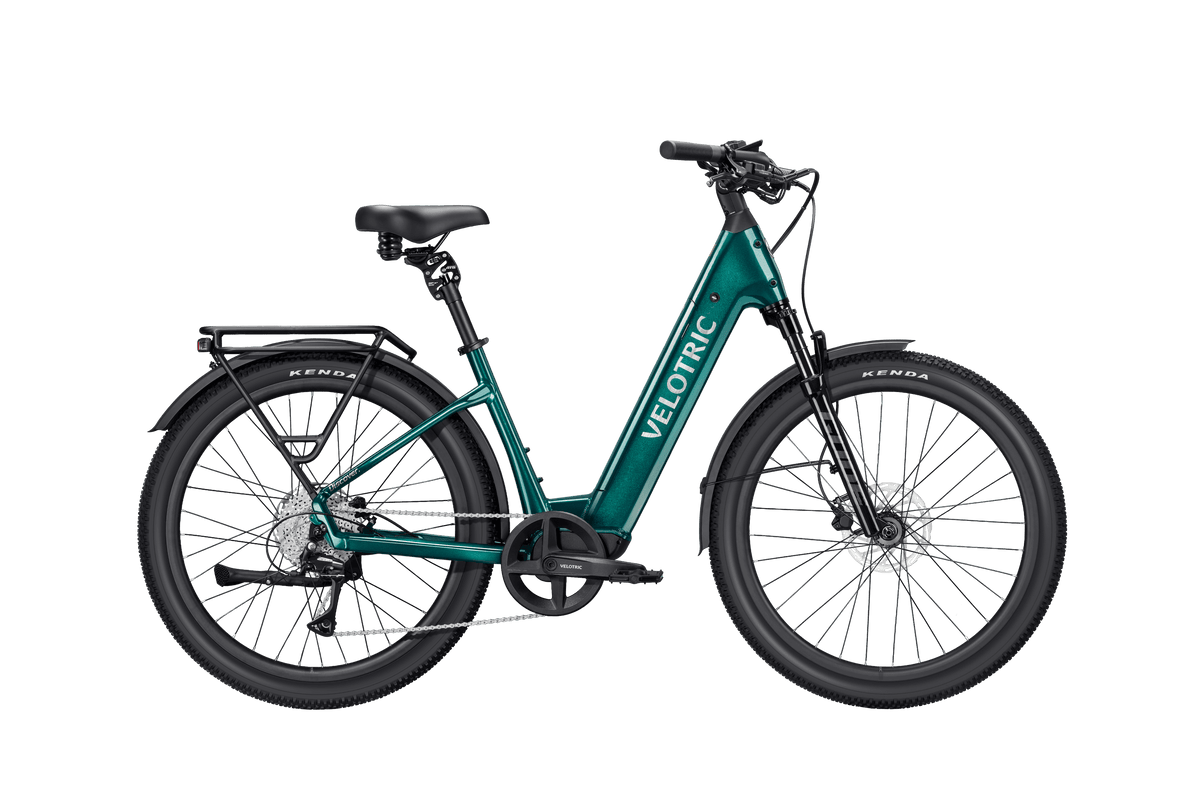 Velotric Discover 3 electric bike in metallic teal with step-through frame, black saddle, wide tires, and rear cargo rack