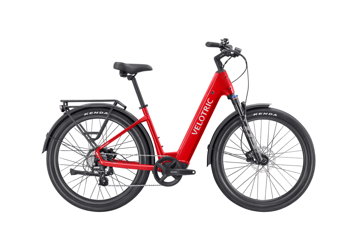 Velotric Discover 3 electric bike in bright red with step-through frame, black saddle, Kenda tires, and integrated rear rack